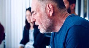 Closeup of person talking in a group with other members of the group in the background